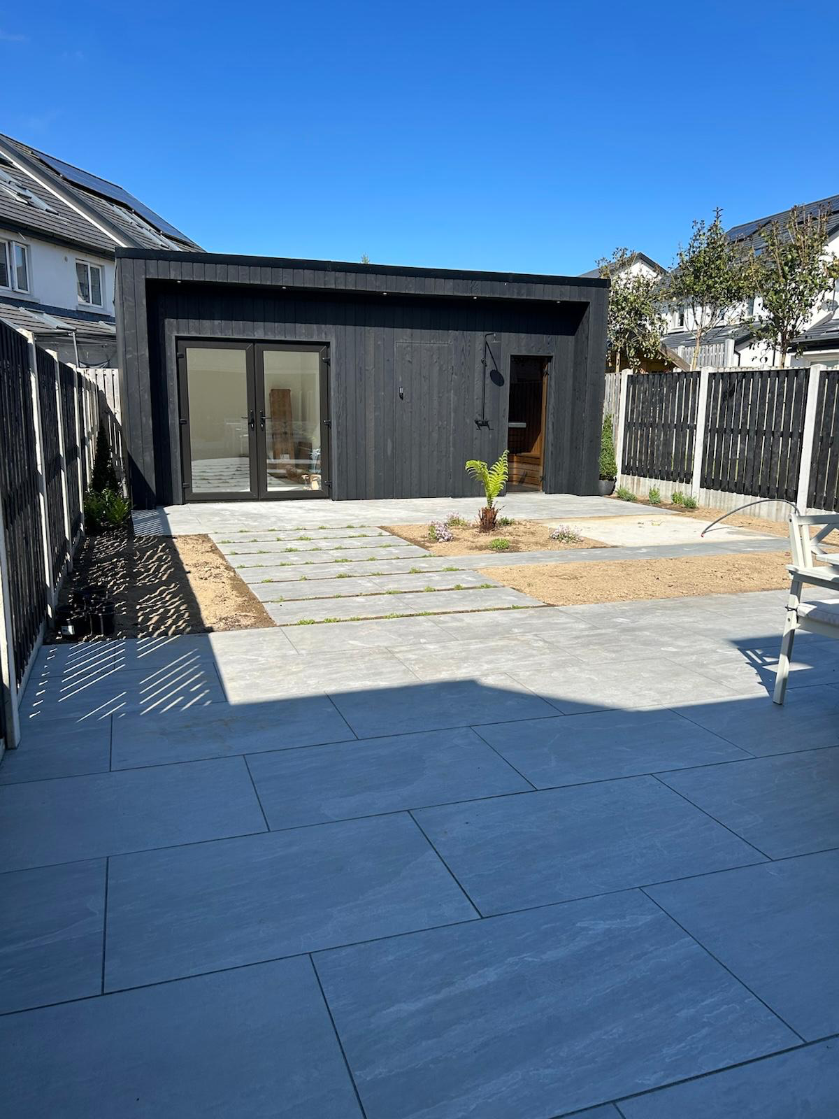 Wide garden view of black garden room and porcelain paving, Dublin