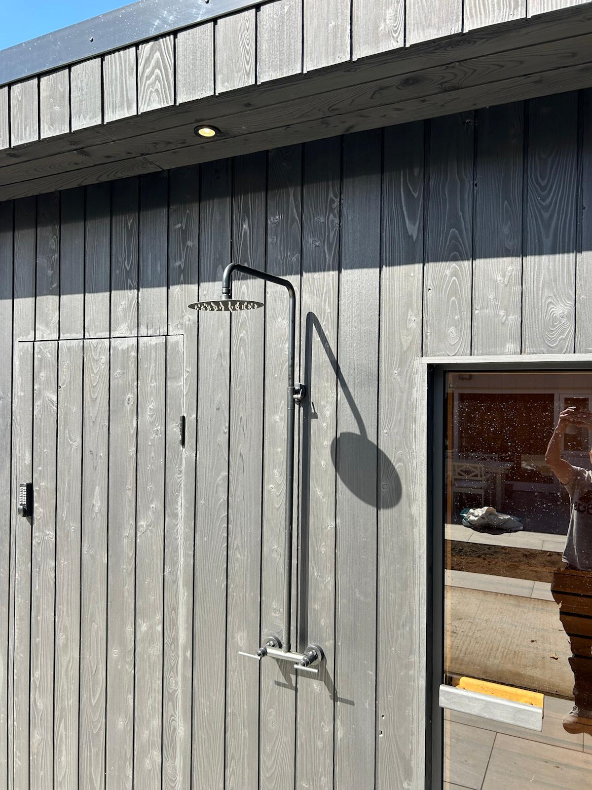 Outdoor cold shower mounted on charred larch cladding