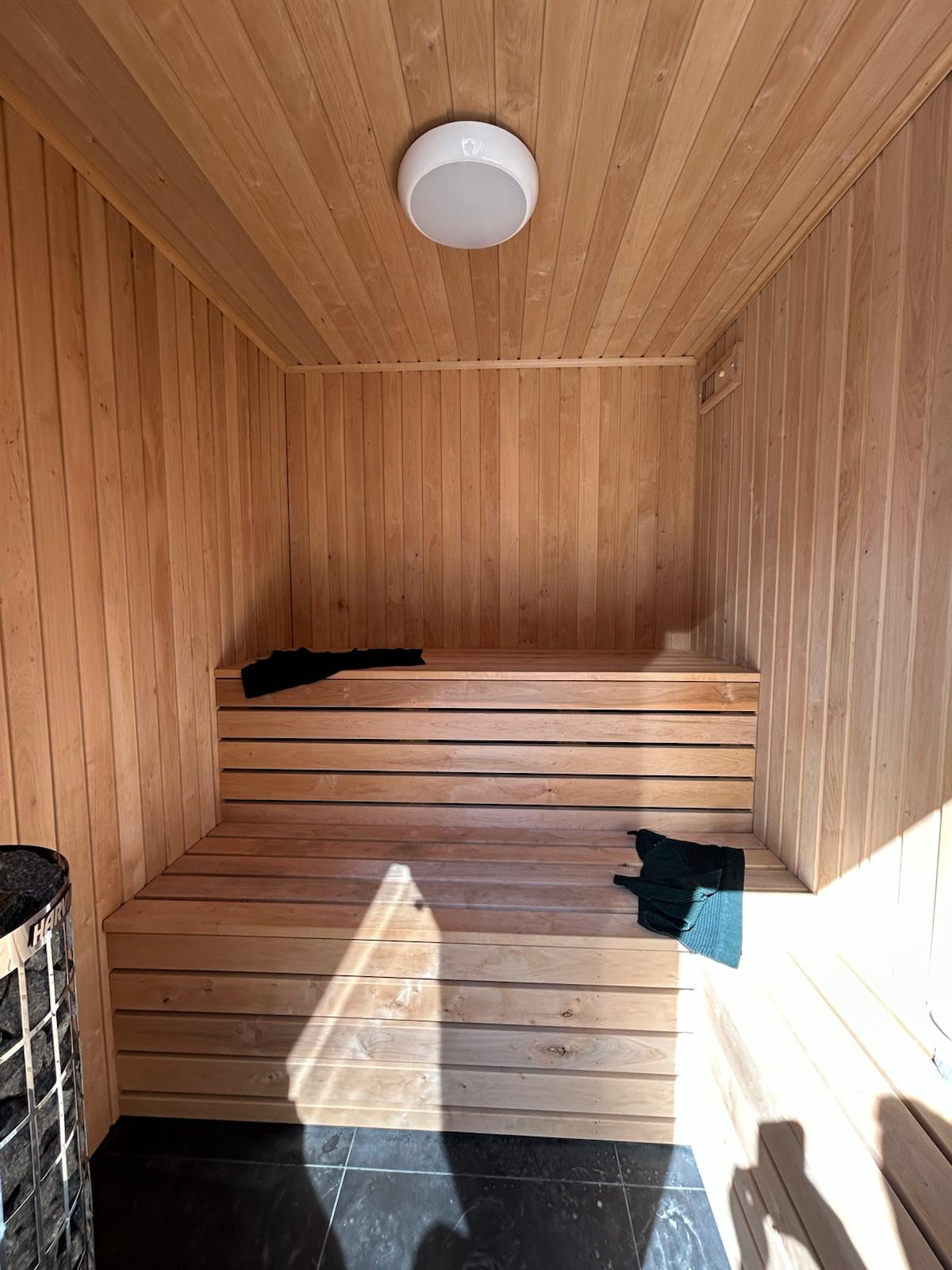 Cedar sauna interior with tiered benches and Harvia heater