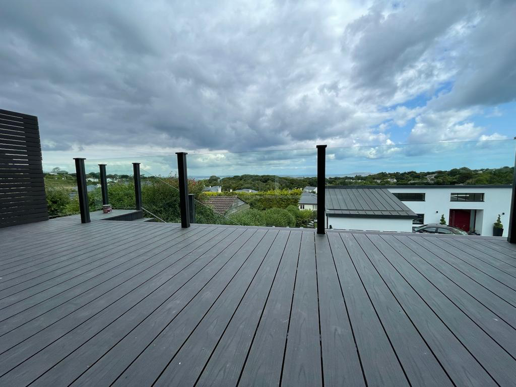 Rooftop composite deck with glass balustrade and panoramic garden view