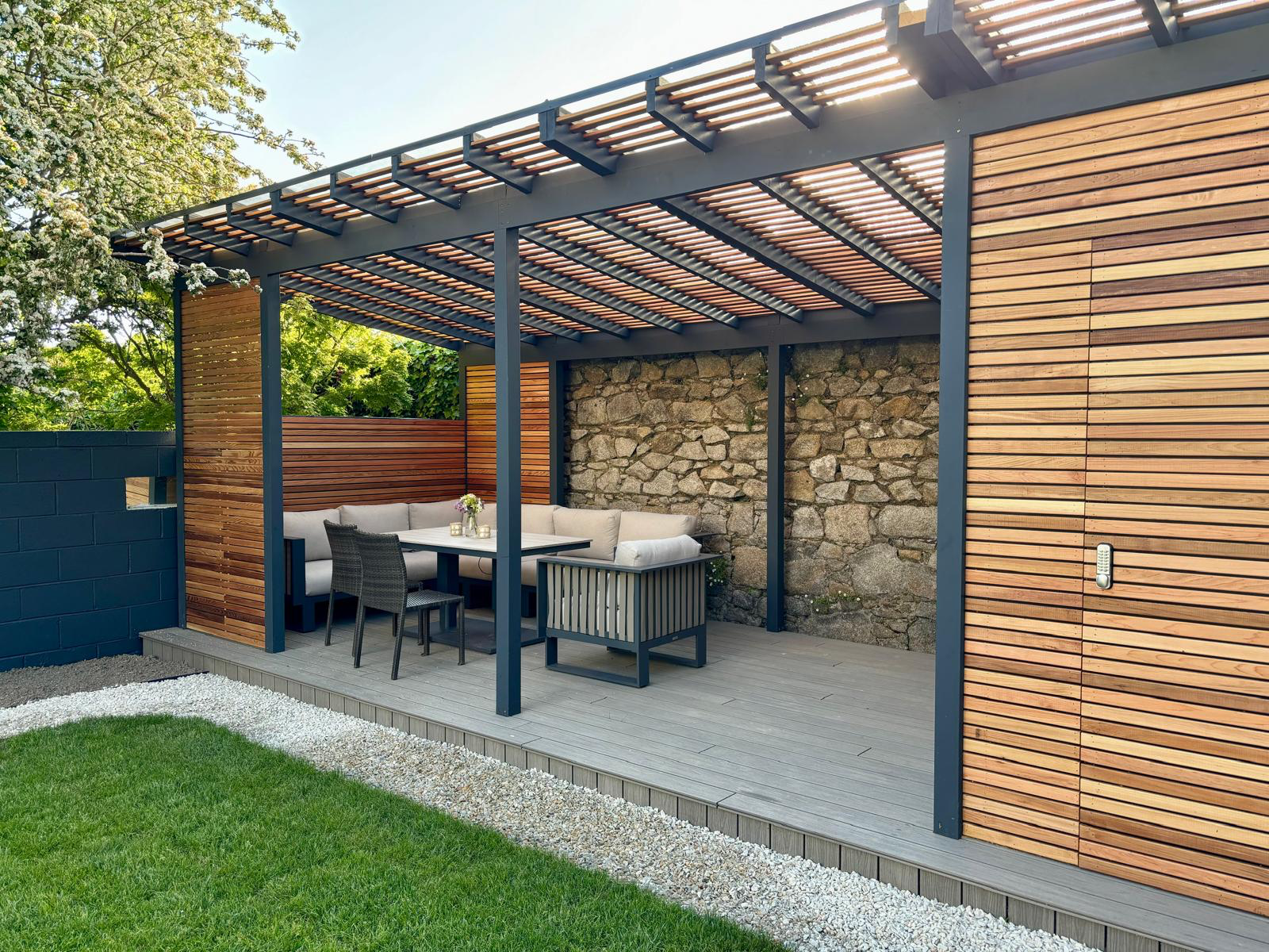Cedar pergola with horizontal screening and original stone wall — front angle