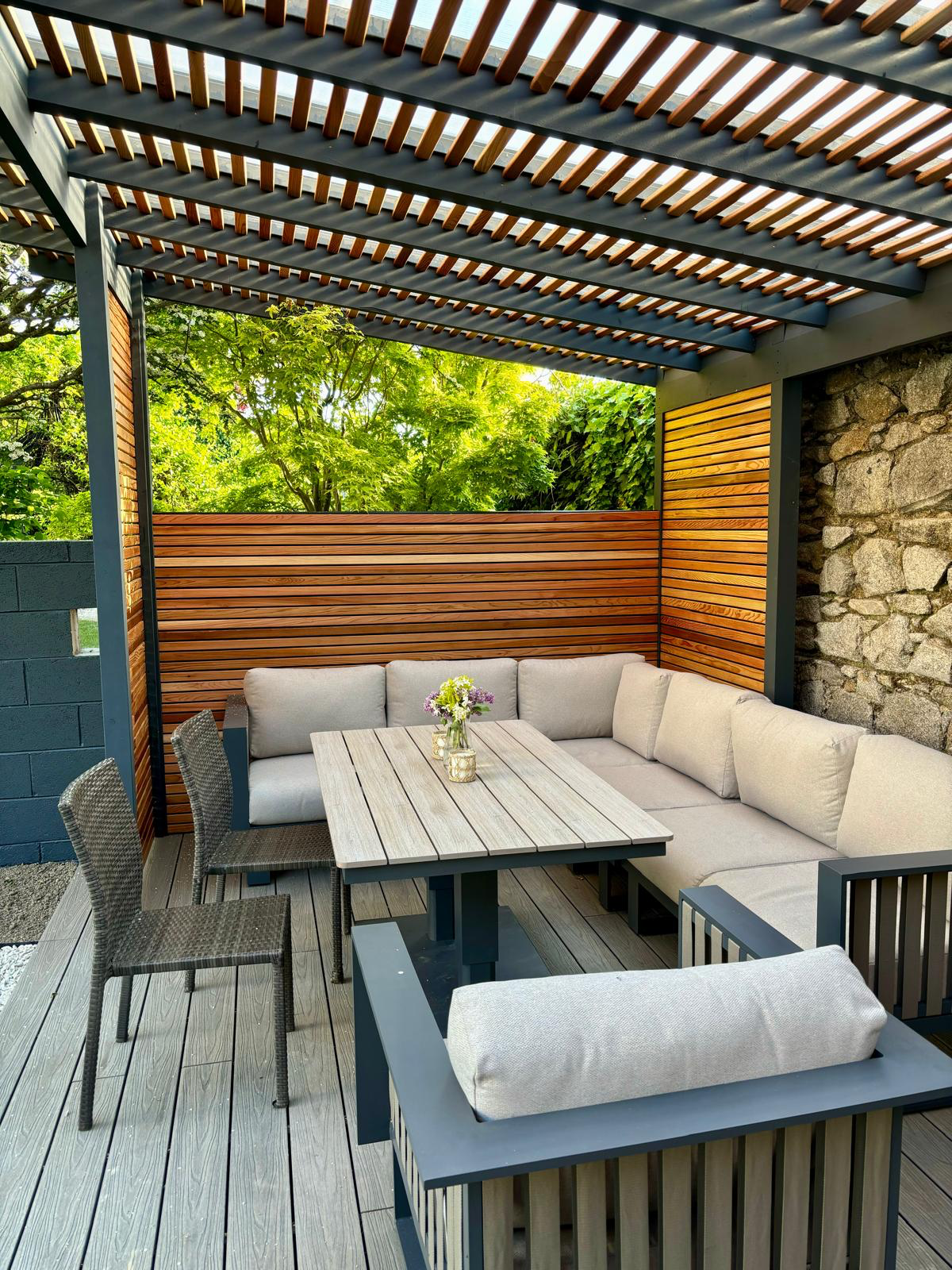 Under the pergola — louvred roof, cedar screening, lounge and dining seating
