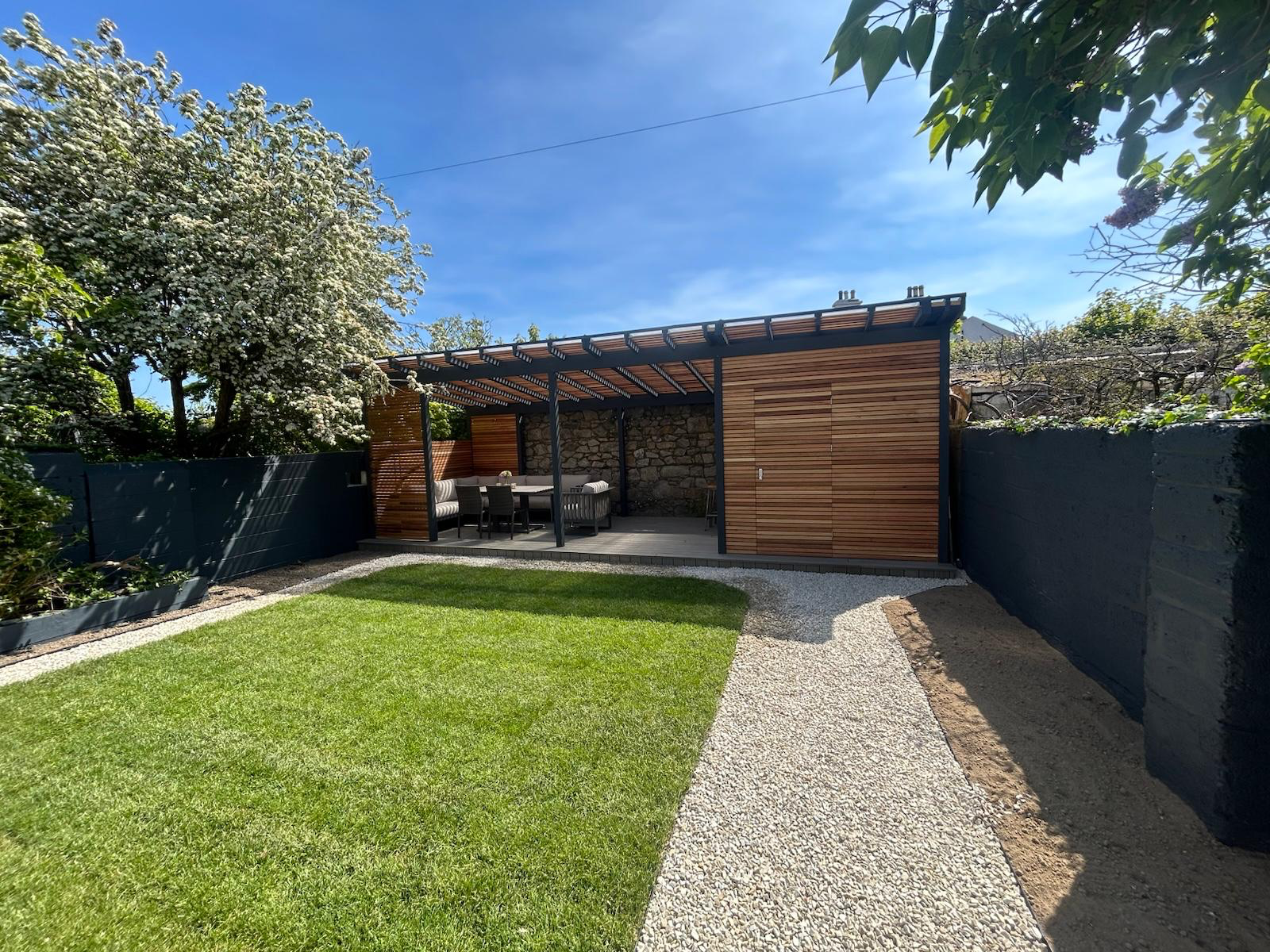 Wide garden view showing lawn, gravel paths and cedar pergola