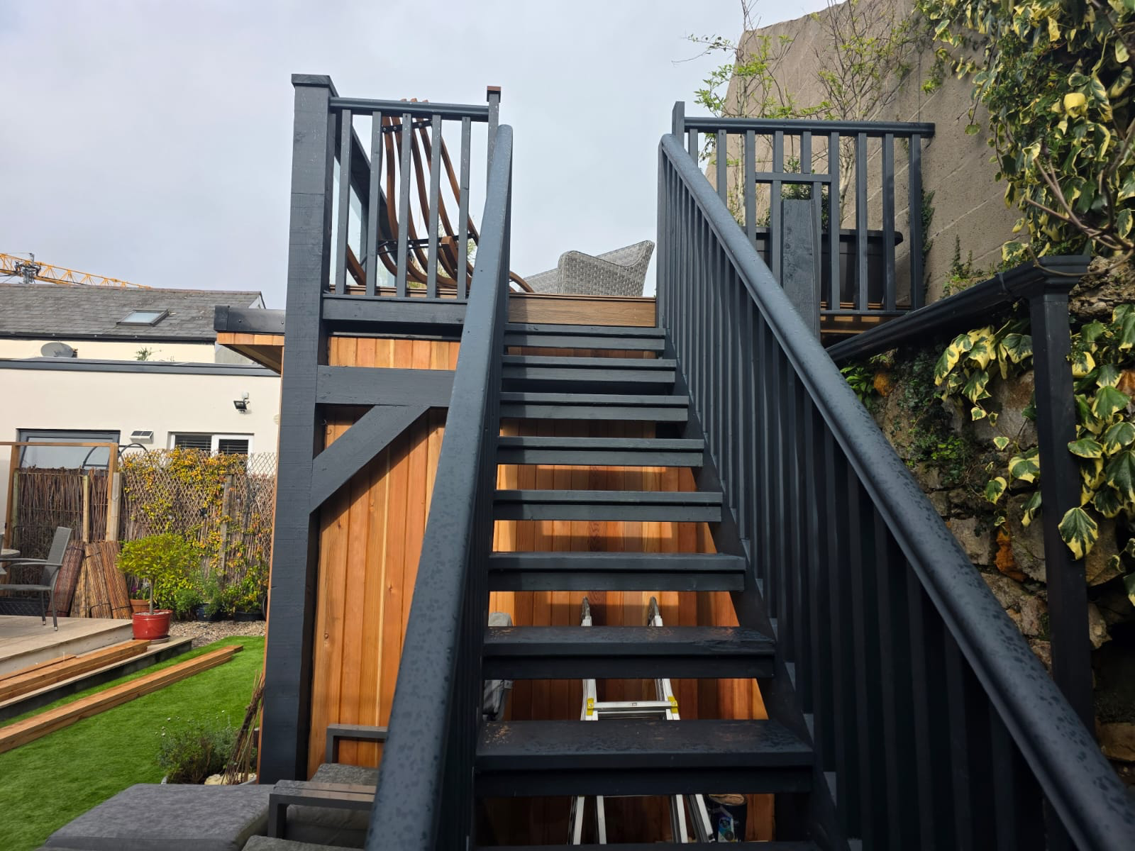 Anthracite external staircase with timber handrail leading to rooftop terrace